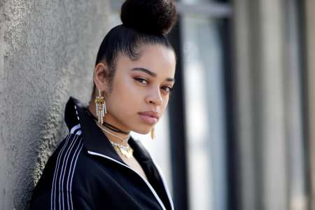 Singer Ella Mai Giving an intense  Sideburns flaunting a Pearl-earring and Gold Necklace